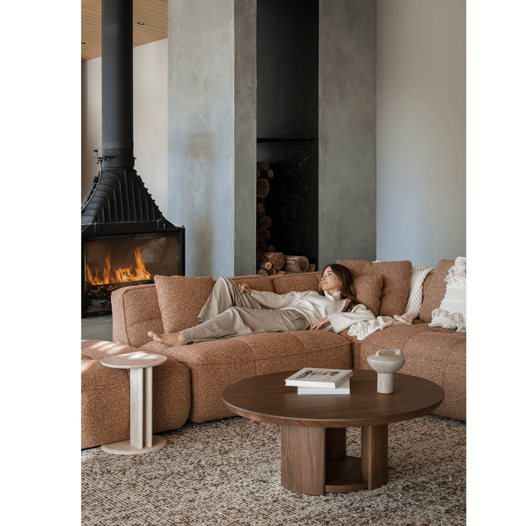 Granite Lane exclusive round travertine Roquette side table in living room.