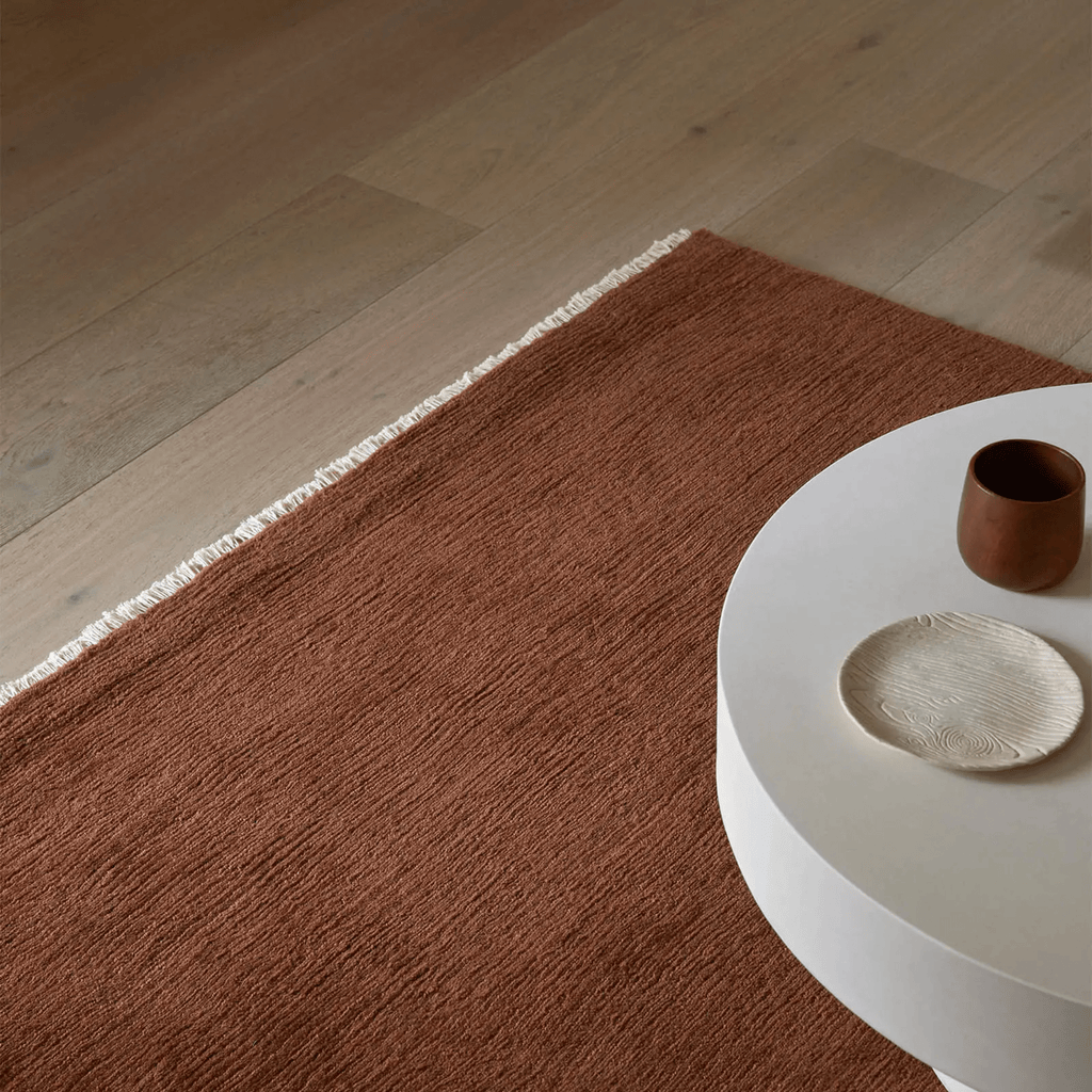 Clay coloured Alessandre floor rug with modern geometric pattern in living room setting