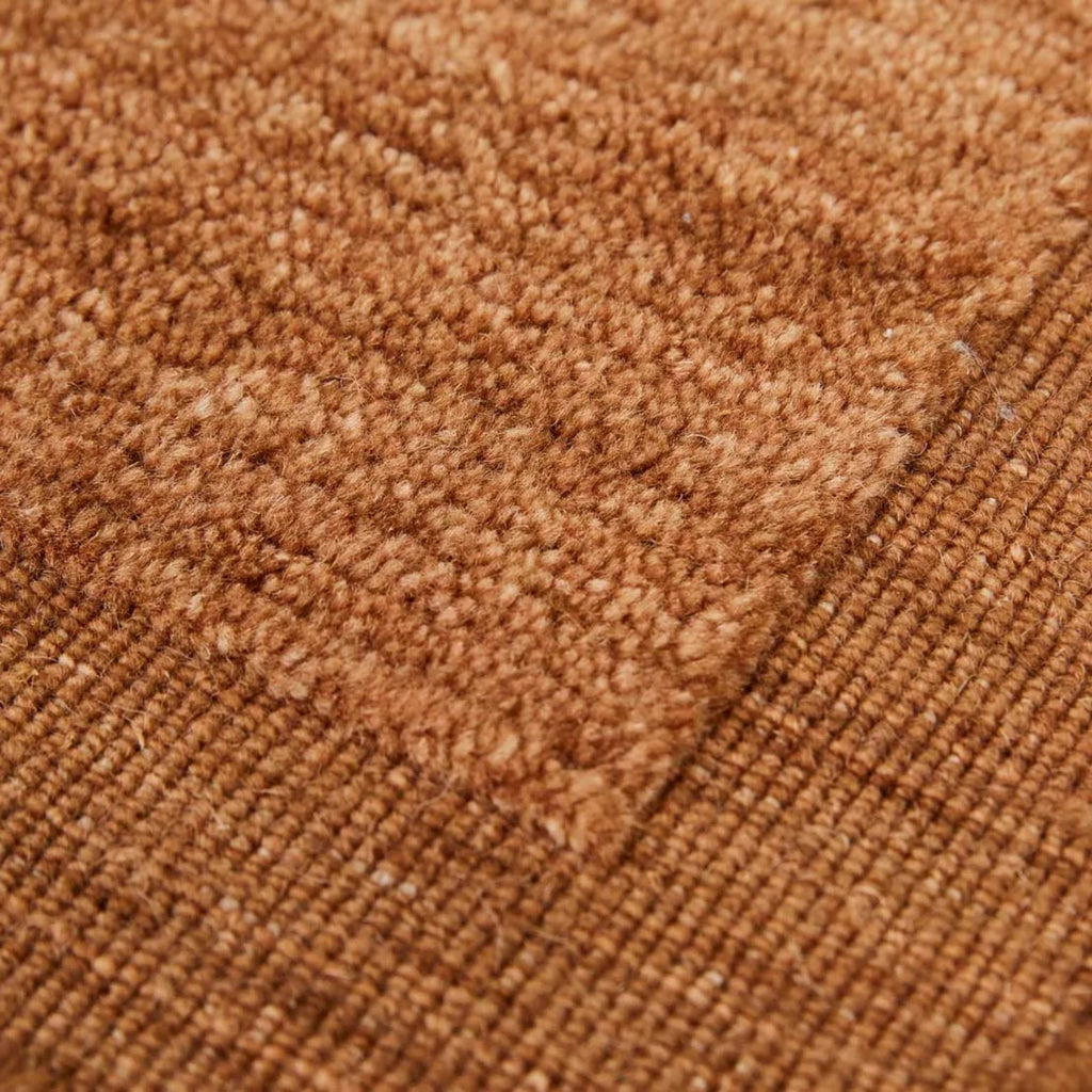 Close up of GlobeWest Bower Frame Rug Rust. 100%wool rug with border.
