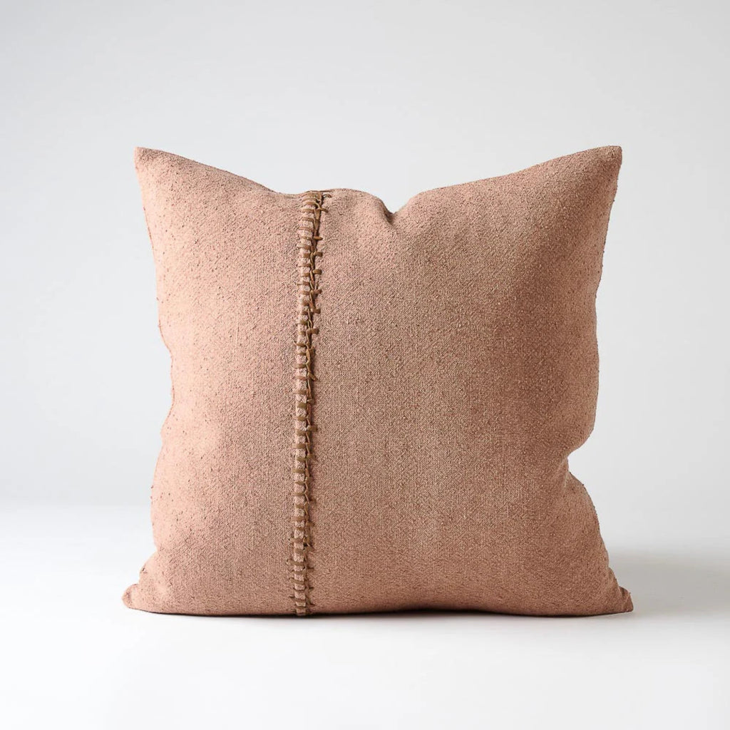 Pink pillow with a textured pattern and decorative trim on a light gray background leather stitch detail by Eadie Lifestyle