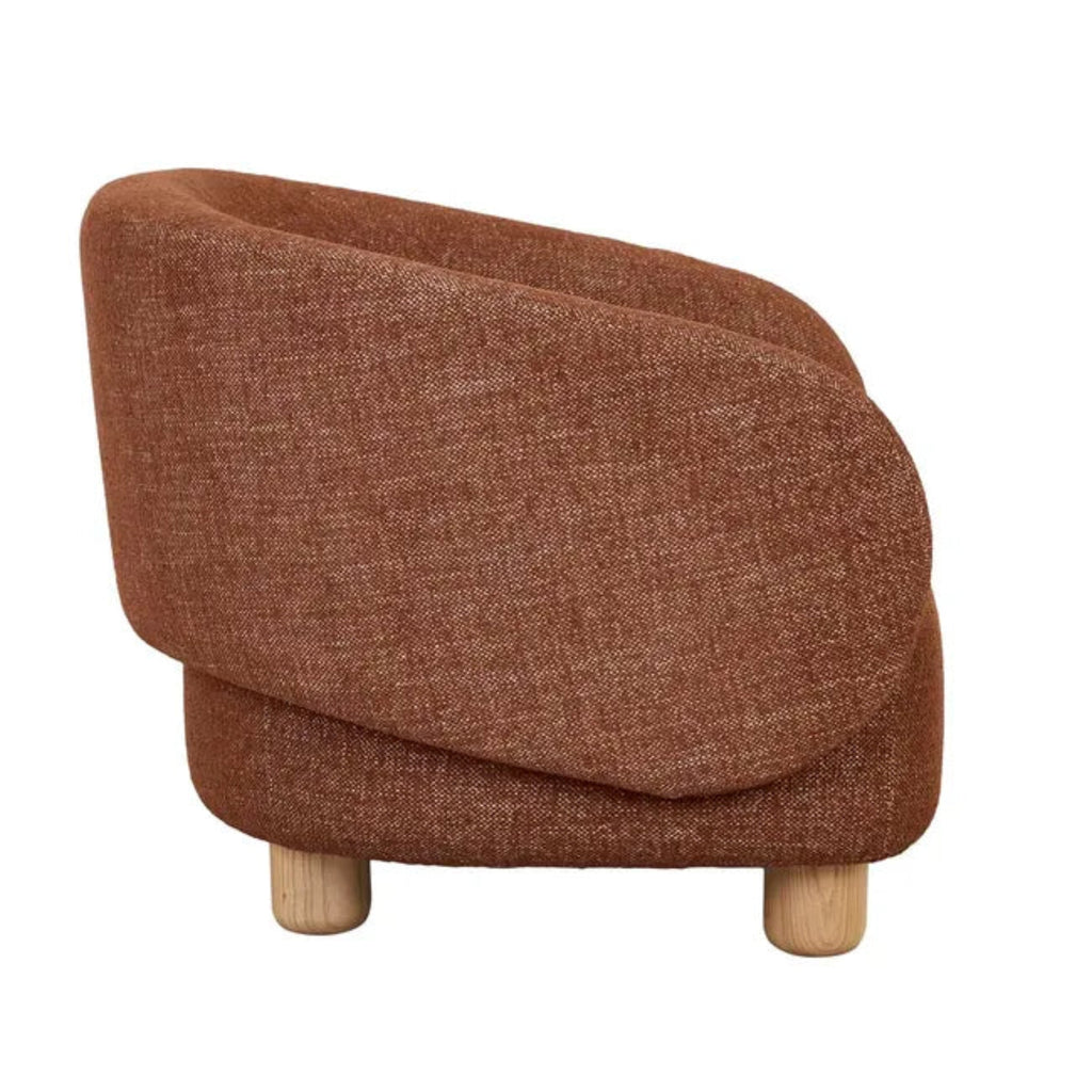 Flo Occasional Chair in brick fabric, side angle view highlighting the chair's ergonomic curve and natural ash wooden leg detail