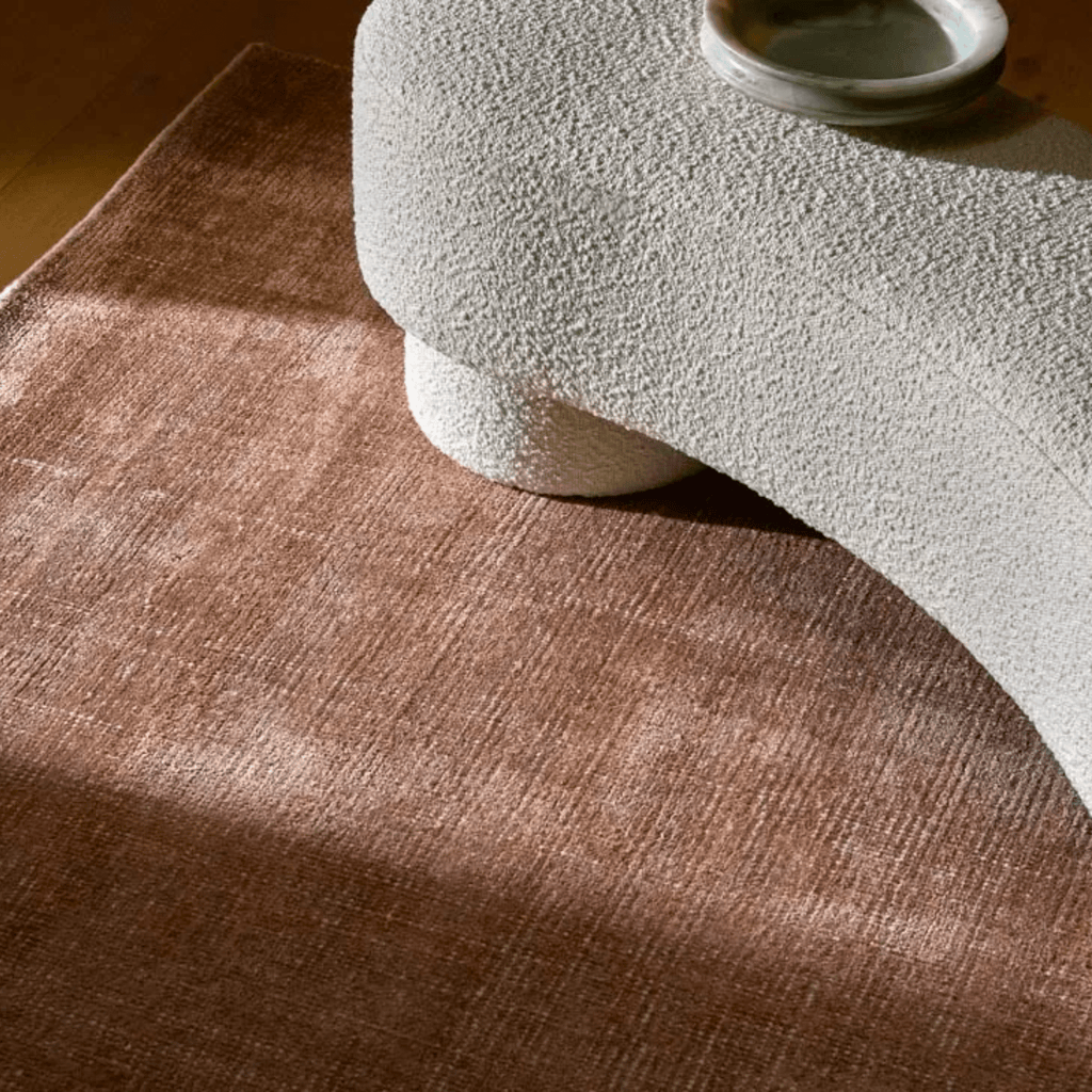 Living room featuring Tepih Neptune Rug in Dusty Rose with plush wool blend, styled under a ottoman.