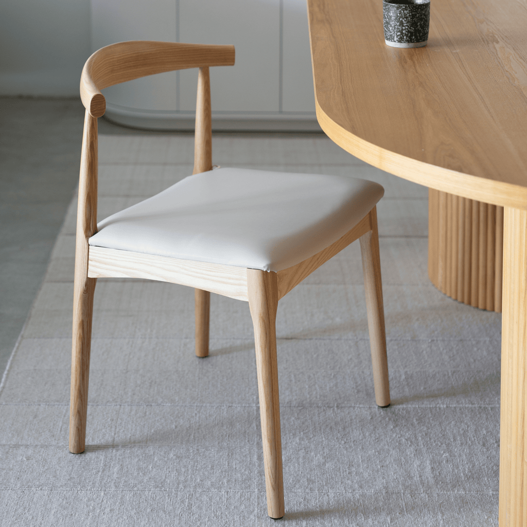 Granite Lane Charlie Dining Chair, tapered ash legs, soft vegan leather seat in bone tone.