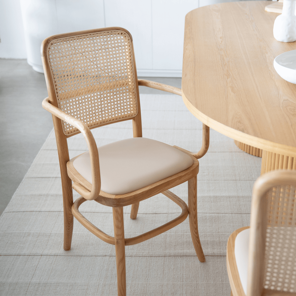 High-back Lacie Dining Chair with curved arms, nude upholstery, solid ash frame and rattan detailing