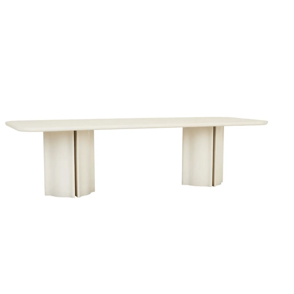 Leon porcelain‑toned dining surface resting on sculptural, contoured column legs, all in a pale, creamy veneer