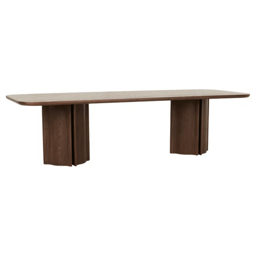 Warm, deep-toned ash veneer Leon Dinig table with a smooth-edged top and sculptural fluted pillar supports in tobacco hue.