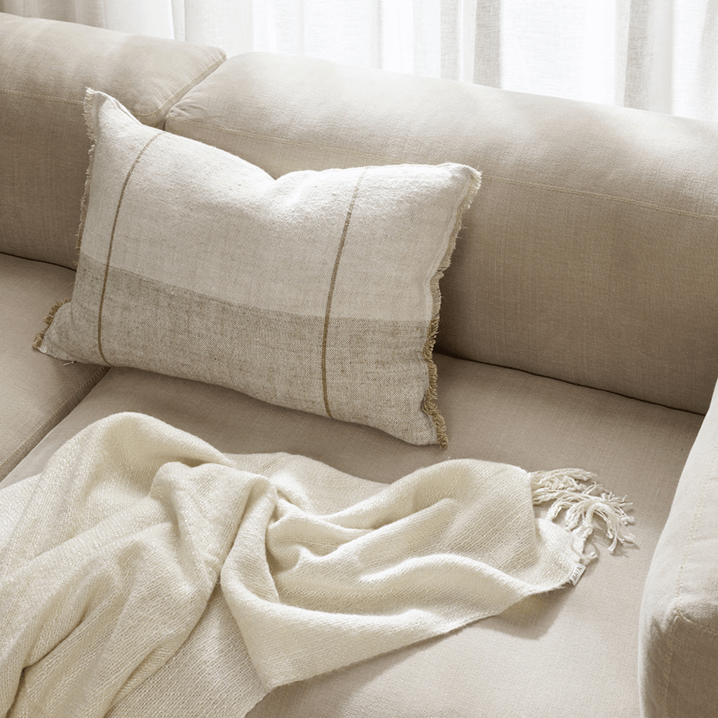 Baya Oliver Sand Cushion in sandy beige tone on armchair