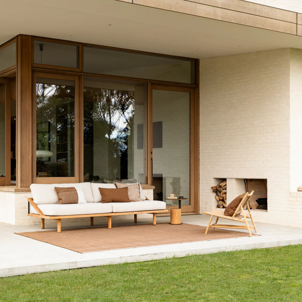 Baya Piper Cushion Tobacco styled in outdoor setting with natural textures and warm tobacco hue