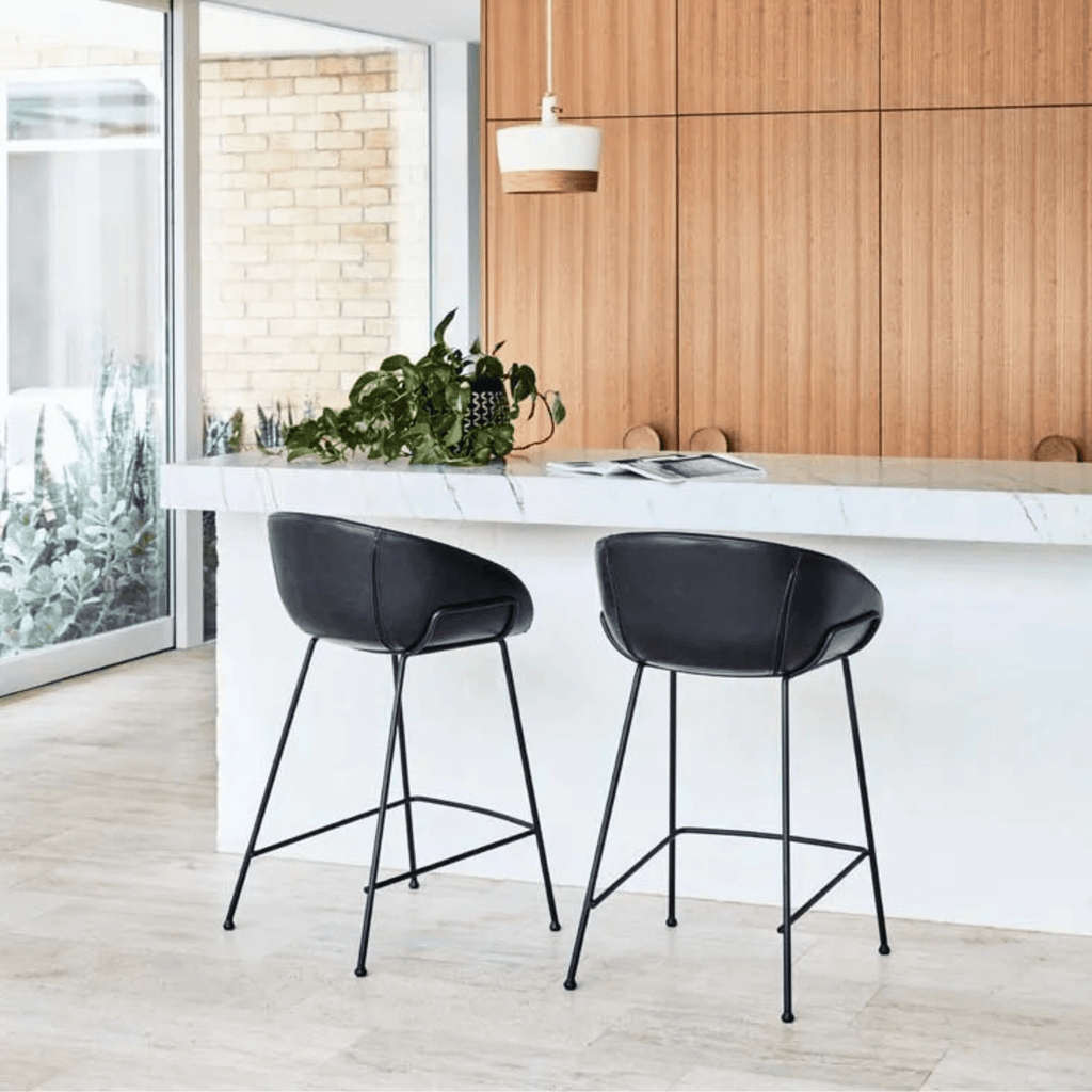 Duke Barstool in vintage green PU styled at a kitchen counter, combining industrial black metal frame with soft upholstery for a contemporary space.