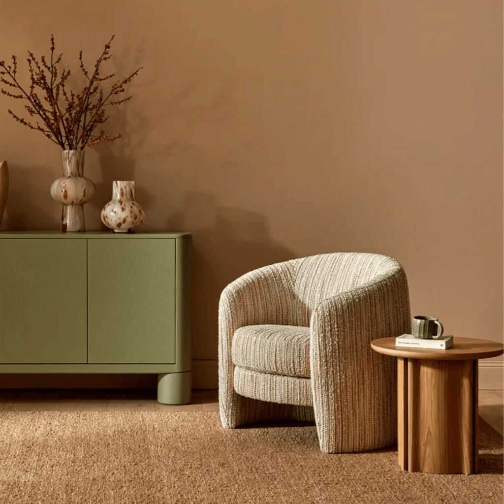 Kennedy Tenner occasional chair styled in a living room setting, upholstered in soft moss velvet with a contemporary curved design.