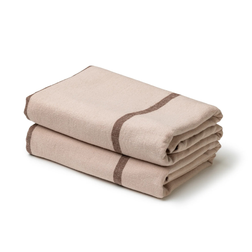 Folded beige towel with brown stripes on a white background